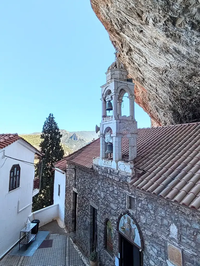 A building with a bell tower and a stone wall